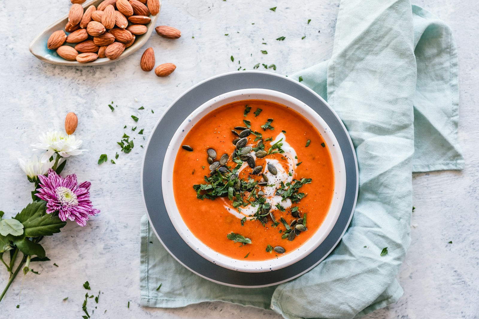 Bowl of charred tomato and basil soup with a swirl of cream and olive oil