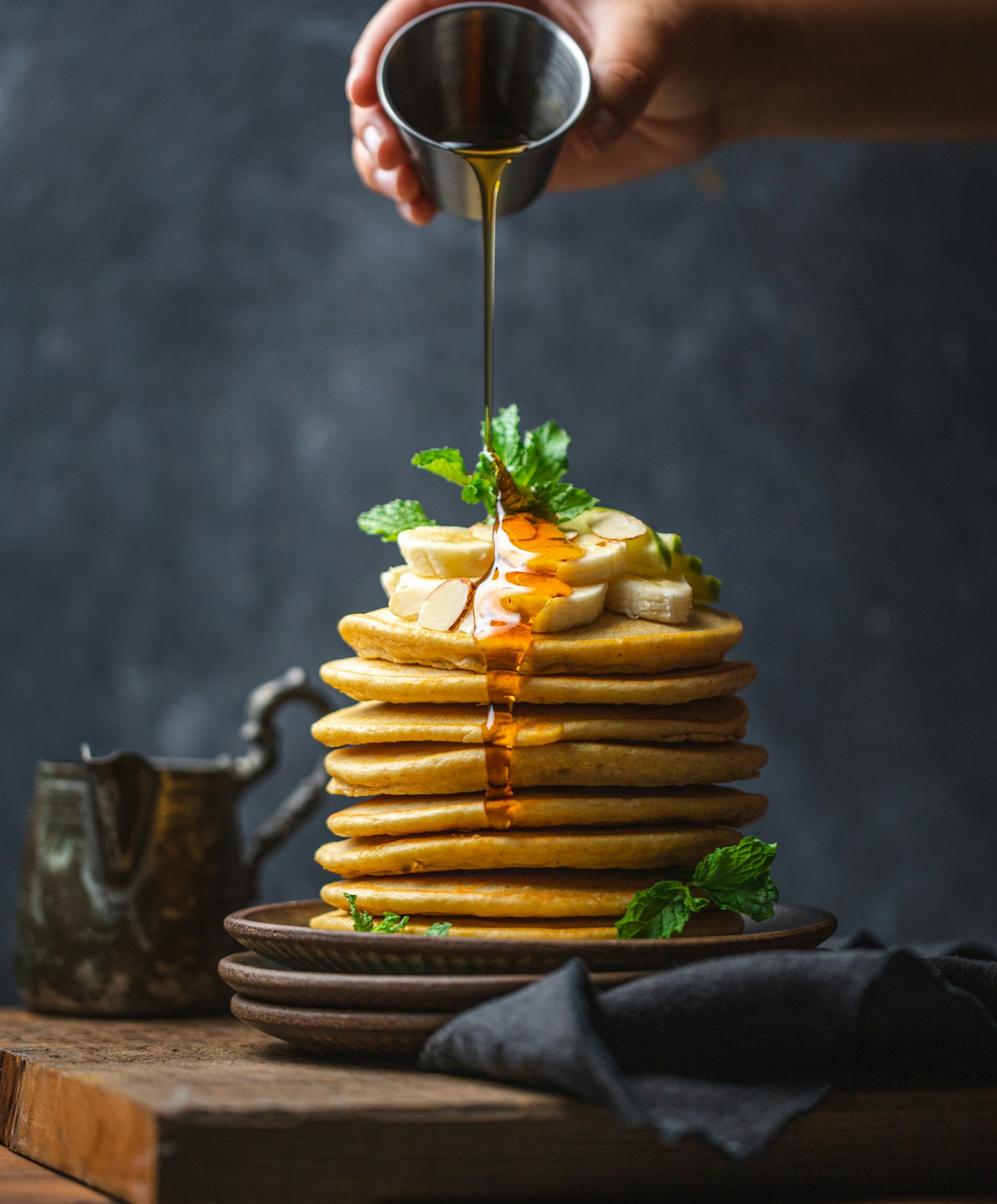 Stack of golden ricotta pancakes with butter and syrup running down the sides
